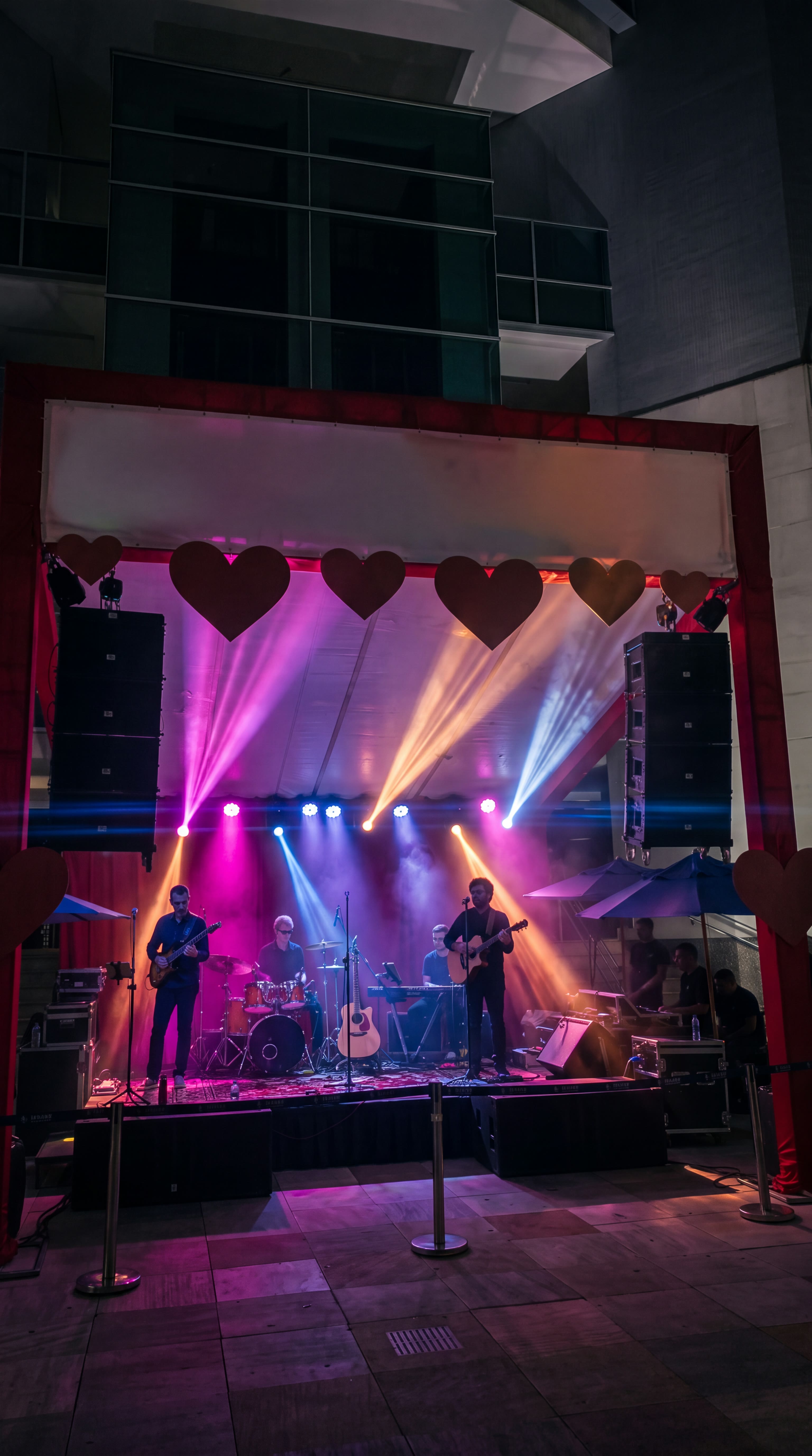 Banda tocando ao vivo sob feixes de luz